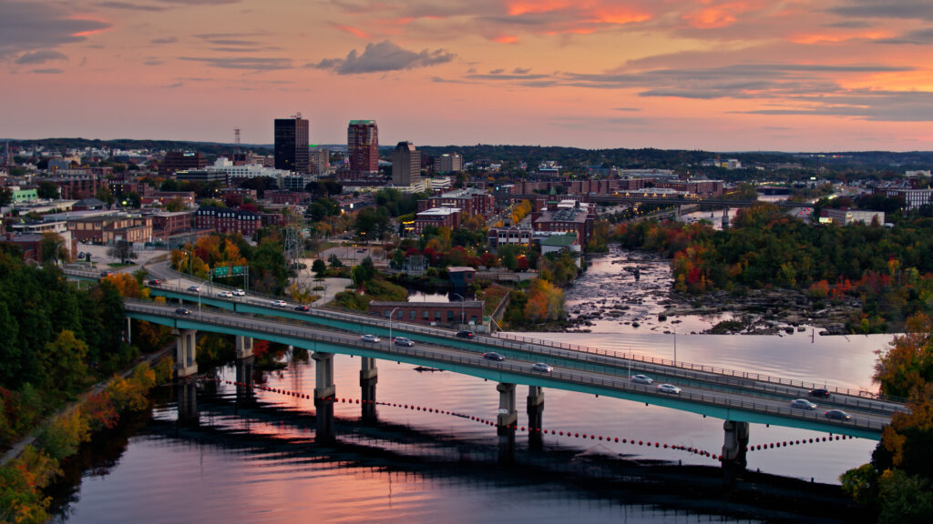 Aerial establishing shot of Manchester, New Hampshire in Fall, with a colorful sunset sky.